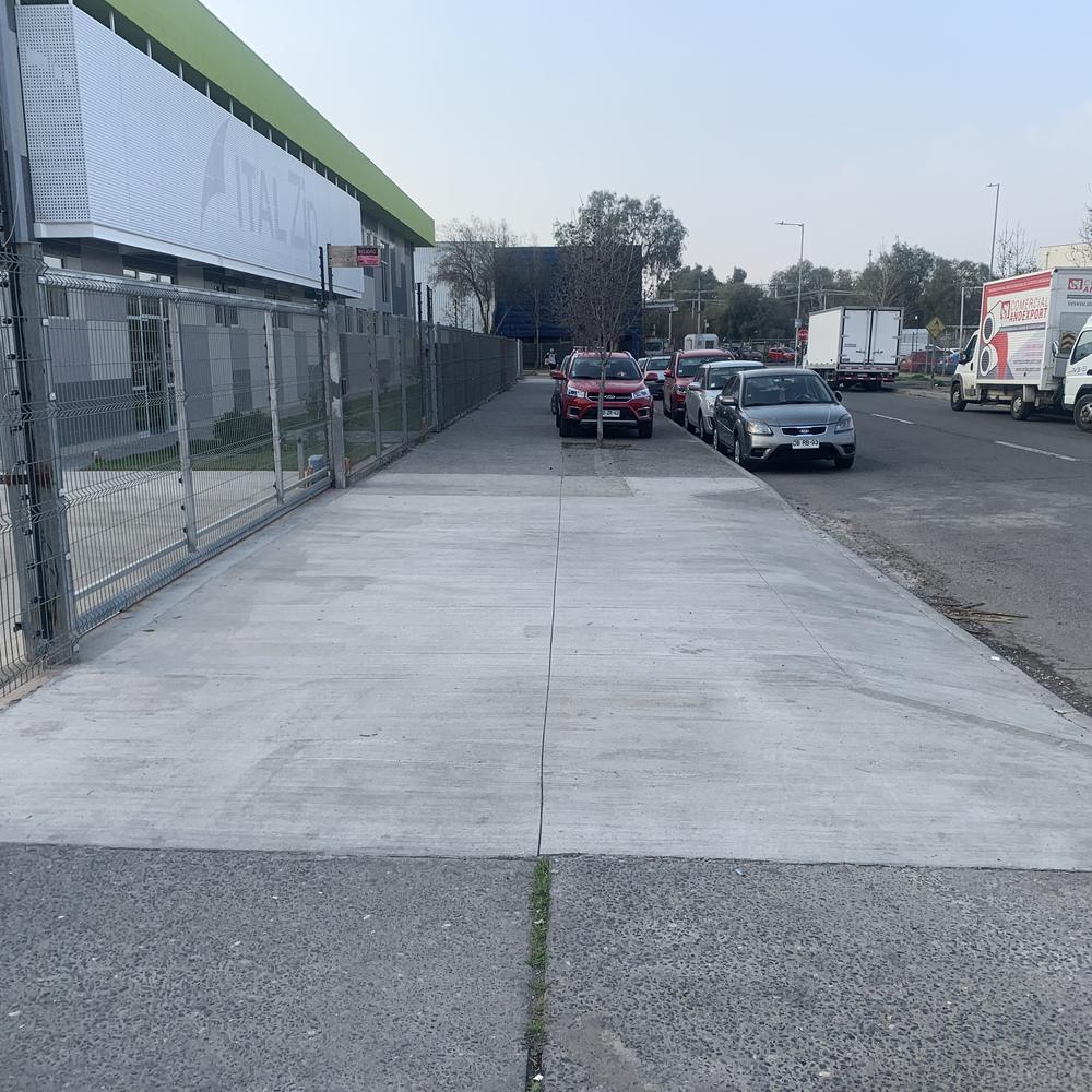 Después: vereda nueva en hormigón frente a recinto industrial